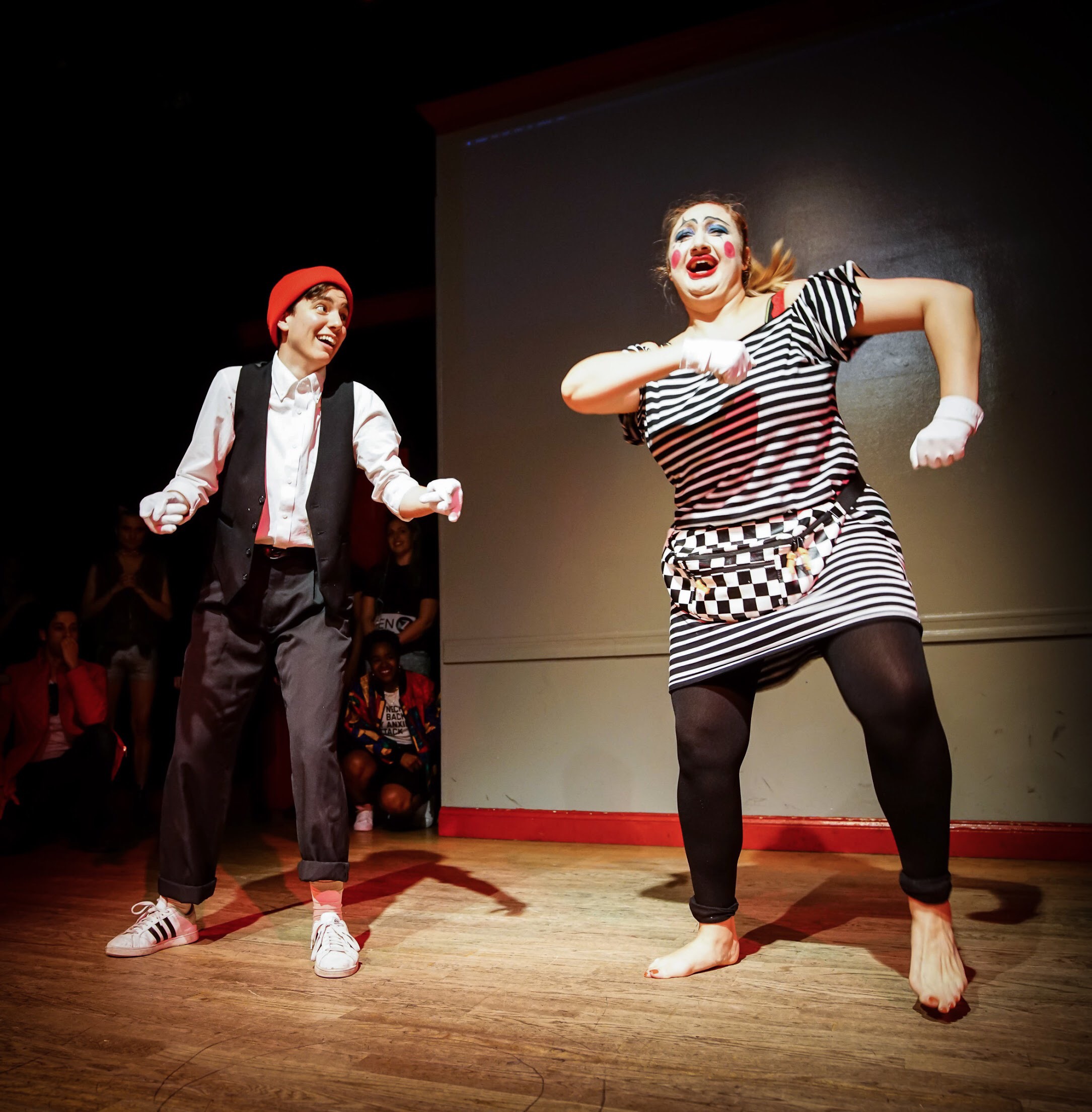 Two mime clowns jauntily dance onstage